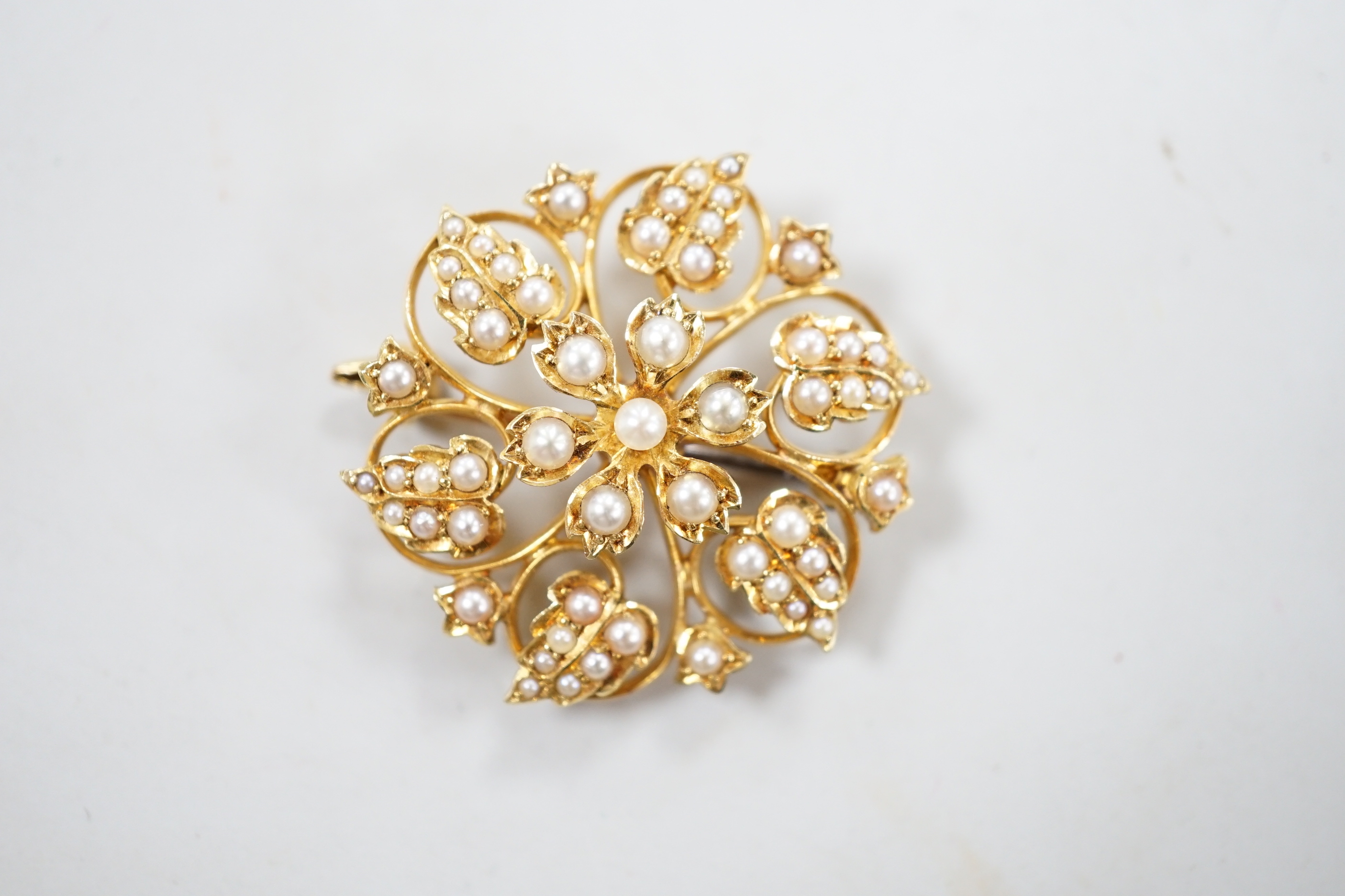 An Edwardian 15ct and seed pearl cluster set flower head brooch, 28mm, gross weight 6.3 grams.